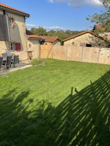 Grande pelouse dégagée devant le gîte, idéale pour les jeux d'enfants en plein air.
