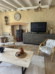 Coin salon avec canapé confortable idéal pour se détendre après une journée au Puy du Fou.