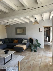 Grand canapé confortable dans le séjour du Logis de l'Orfosse, idéal pour se détendre en famille.