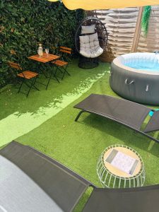 Table et chaises en bois pour repas en extérieur, proche du spa privatif